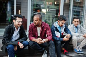 Group of men sitting outside a shop