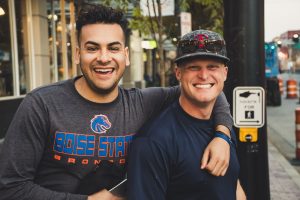 Man with his arm around his friend and laughing